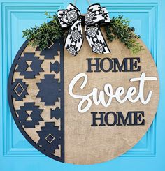 a door hanger with the words home sweet home on it and a bow tie