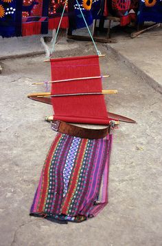 a red piece of cloth hanging from a string with wooden skewers attached to it