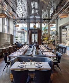 an empty restaurant with long tables and chairs