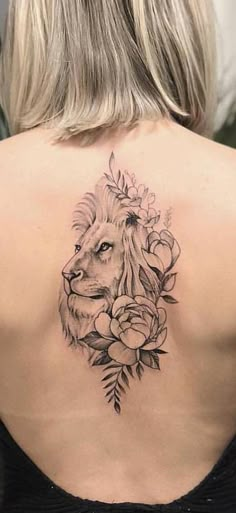 the back of a woman's shoulder with a lion and flowers tattoo on it