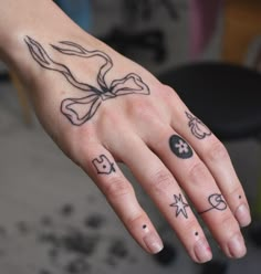 a person's hand with tattoos on it and an inked cross in the middle