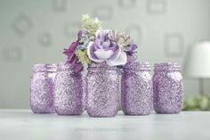 purple glitter mason jars with flowers in them