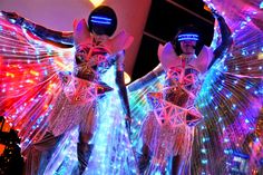 two people dressed in costumes with lights on them