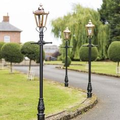 three street lamps on the side of a road