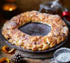 an image of a cake on a plate with powdered sugar and oranges around it