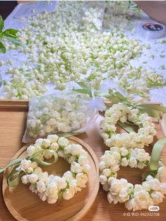 white flowers are laid out on wooden plates