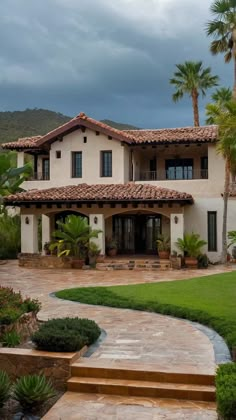 a large white house with palm trees in the front yard and steps leading up to it