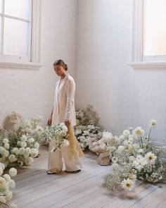 a woman is standing in front of flowers