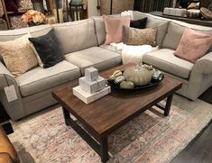 a living room filled with lots of furniture and pillows on top of a wooden table