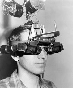 a man is looking through binoculars at something on top of his head, with multiple cameras attached to it