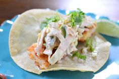 a taco filled with meat and garnish on top of a blue plate