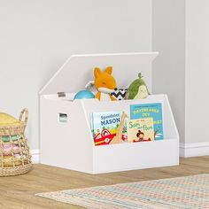 a toy storage box with books and toys in it next to a basket on the floor