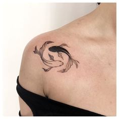 a woman with a tattoo on her shoulder has a fish in the middle of it