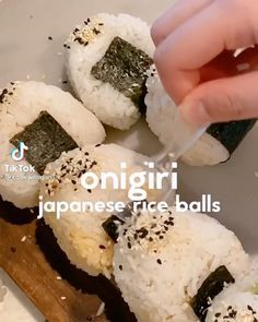 someone is cutting up sushi on a plate with chopsticks and rice balls