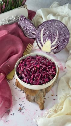 red cabbage in a bowl next to a knife and fork