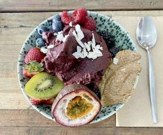 a bowl filled with fruit and nuts on top of a wooden table