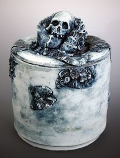 a ceramic container with a skull and flowers on it