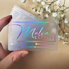 a person holding up a business card with the name madam events on it next to some flowers