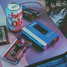 a table topped with an old fashioned cassette player and a can of cheer cola on top of it