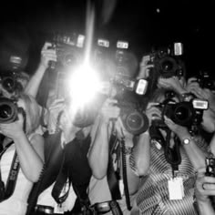 a group of people with cameras taking pictures