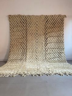 a large woven rug with fringes on the floor