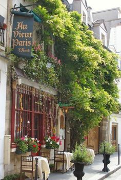 the outside of a restaurant with tables and chairs