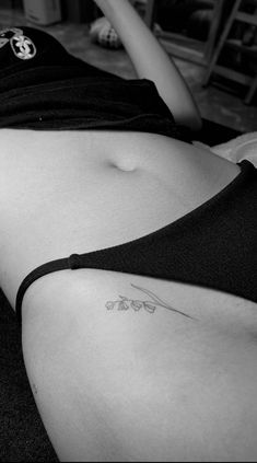 a woman laying on the floor with her stomach tattoo