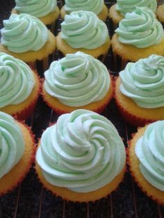 cupcakes with green frosting sitting on a cooling rack