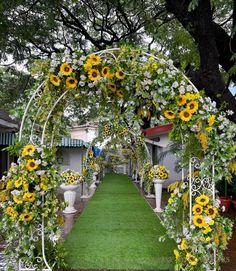 an outdoor wedding ceremony with sunflowers and greenery on the aisle, surrounded by white urns