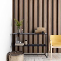 a room with a shelf, chair and vase on the floor next to a wall