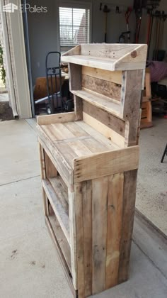 a wooden bench made out of pallets on the side of a building with an open door