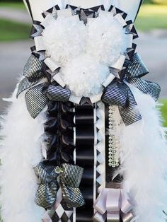 a white and black bow with feathers attached to it