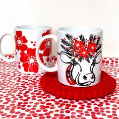 two coffee mugs with red flowers on them and the words, find happy in the everyday