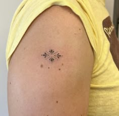 a person with a small tattoo on their left arm and the other arm behind her