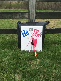 a sign that says he or she? in front of a fence