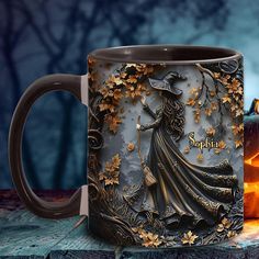 a coffee mug with an image of a witch on it next to a lit candle