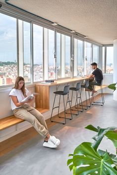 a woman sitting on a window sill in an office