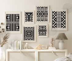 there are many black and white art pieces on the wall in this living room,