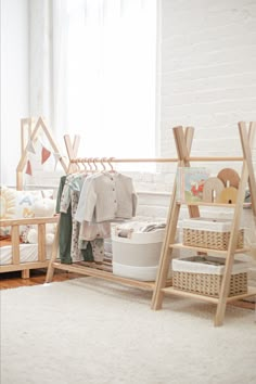 a child's room with clothes and toys on the rack, next to a window