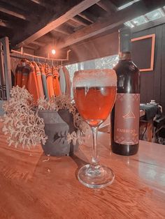 a glass of wine sitting on top of a wooden table