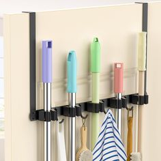 a wall mounted rack with four different colored umbrellas and two black hooks on it