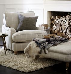 a living room filled with furniture and a fire place covered in blankets on top of a rug