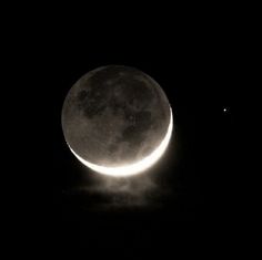 the moon is shown in black and white as it passes through the sky