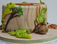 there is a cake decorated with lizards and plants