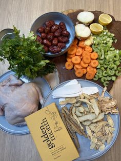 an assortment of vegetables and meat on a plate next to a book with the title