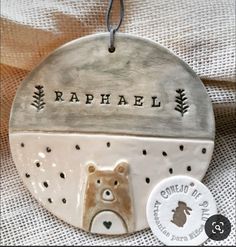 a ceramic ornament with a bear on it's face and the name raphael