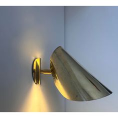 a wall mounted light on the side of a white wall next to a blue wall