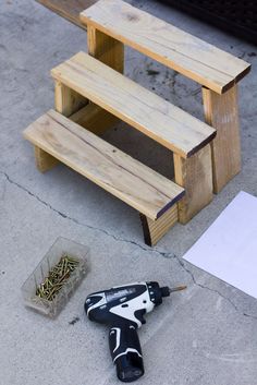 a pair of black and white paint brushes sitting on the ground next to a wooden bench