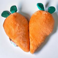 a heart shaped stuffed animal with two green leaves sticking out of it's side