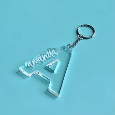 an acrylic keychain with the letter a on it's side